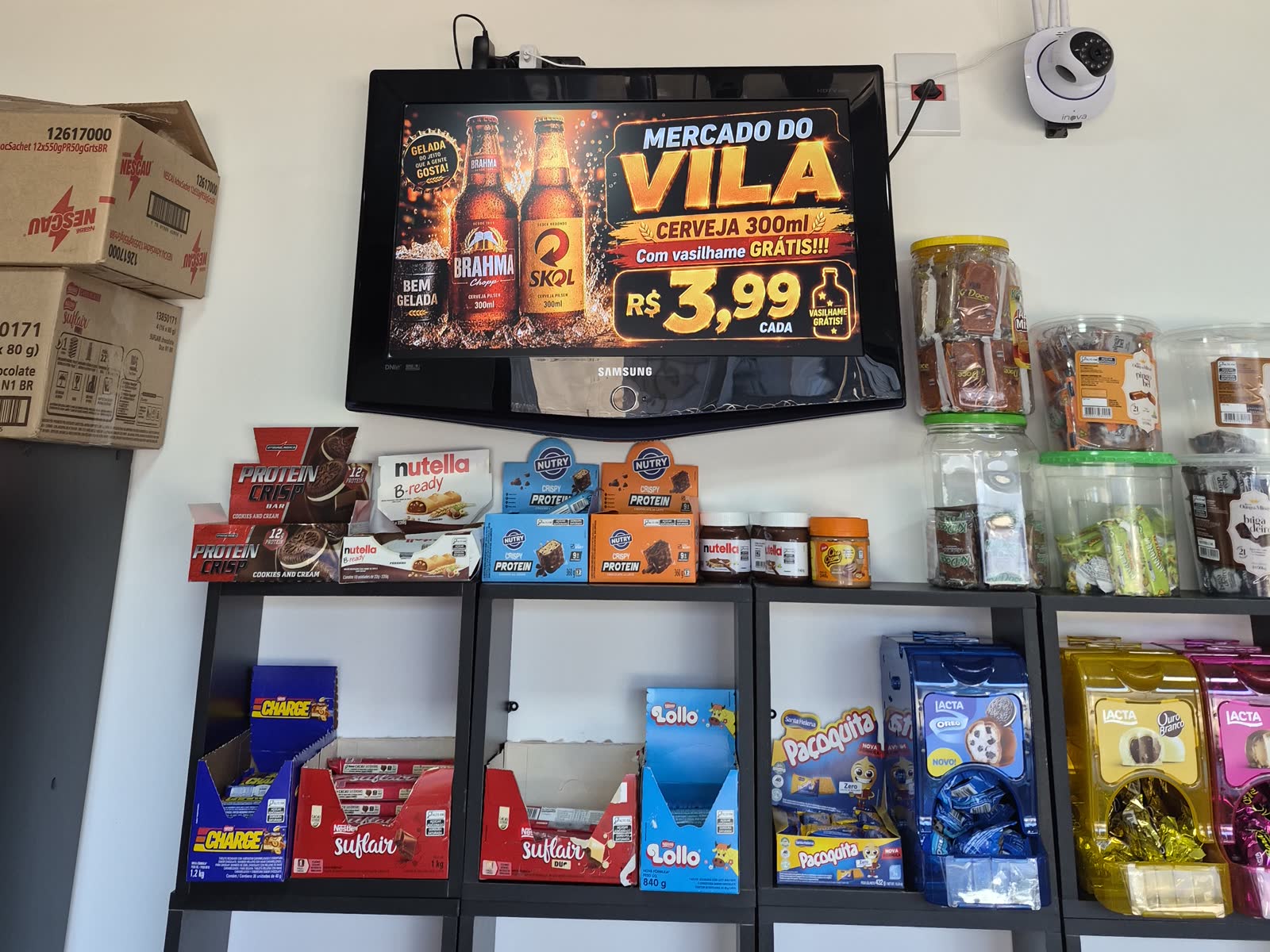TV do exemplo de loja passando um vídeo de promoção de produtos, acima das prateleiras